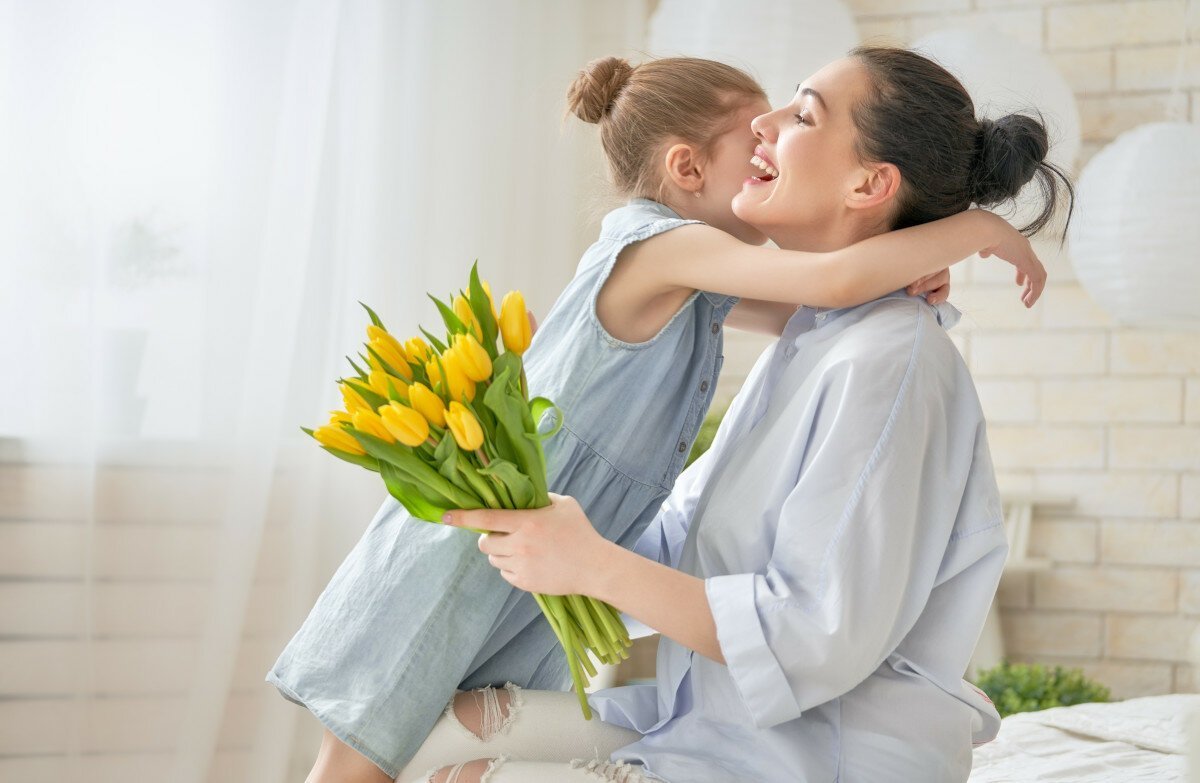 Ребенок дарит цветок маме