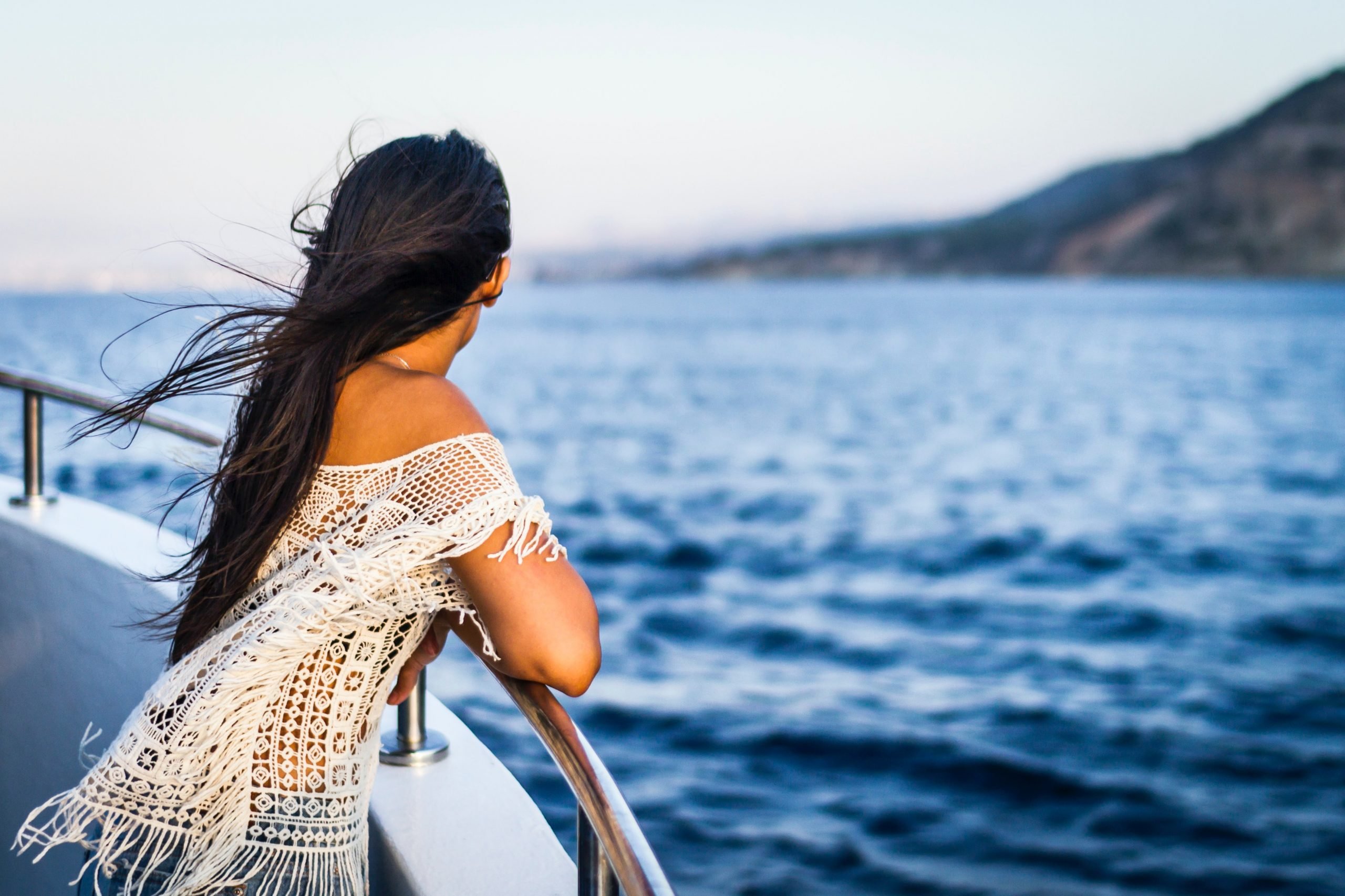 Девушка на берегу моря со спины с поднятыми вверх руками — Фотографии для аватара