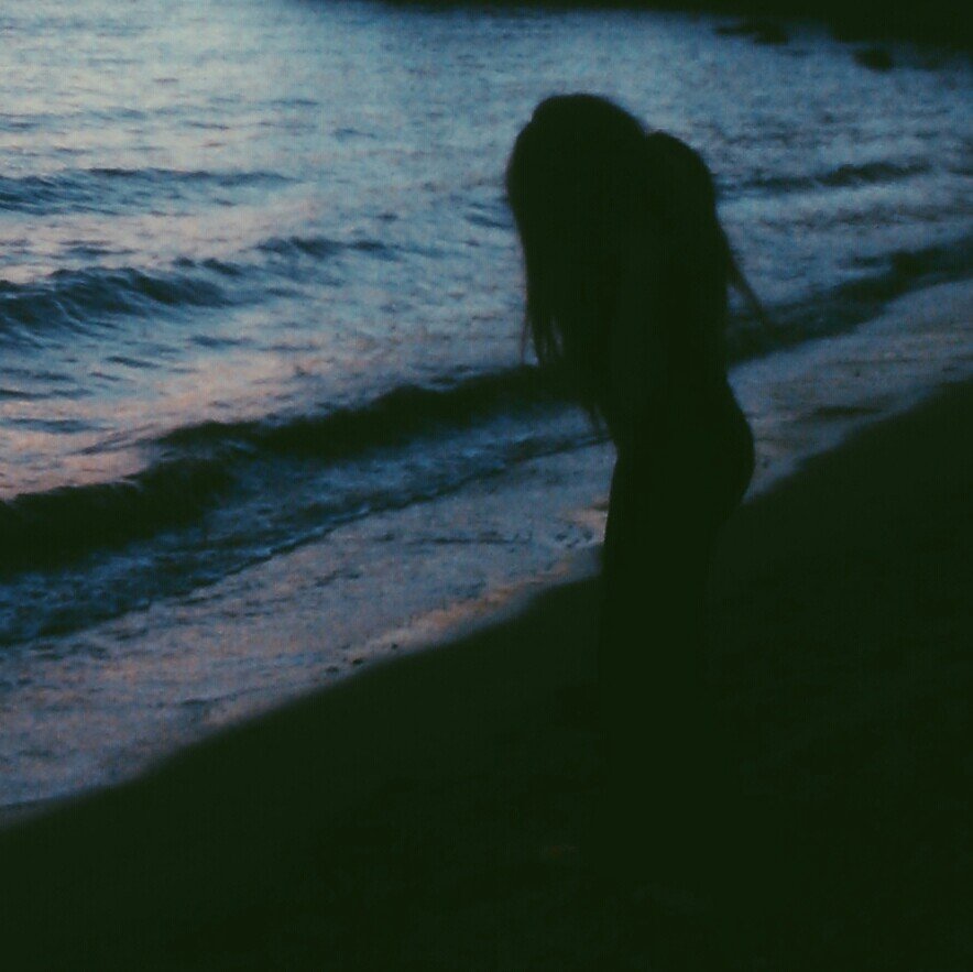 Девушка спиной в темноте фото. Девушка в темноте со спины. Девушка на море в темноте. Девушка на море со спины. Девушка с черными волосами на море.