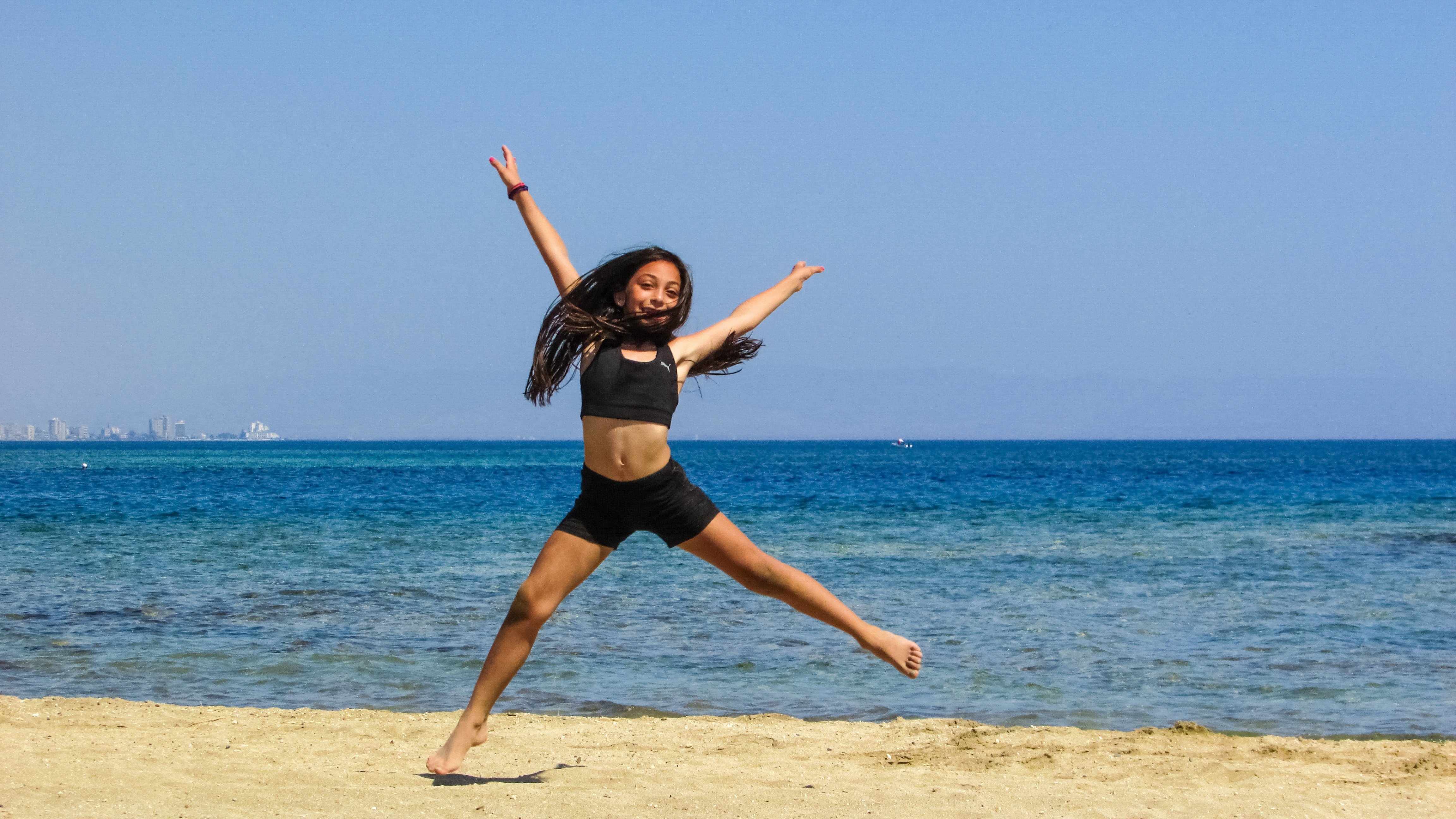 Пляшущие моря. Летние танцы. Девушка танцует на пляже. Гимнастика на море. Танцующая девушка на пляже.