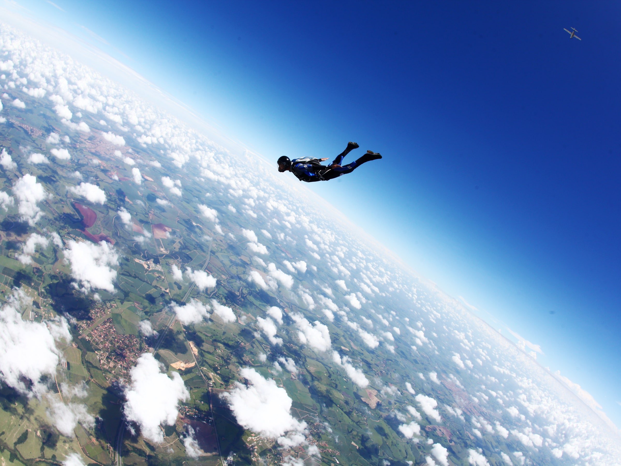Люди падают с самолета. Самолет в небе. Летающий человек. Прыжок с самолета. Земля с высоты.