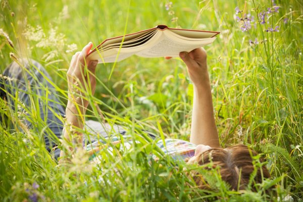 Девушка с книгой на траве