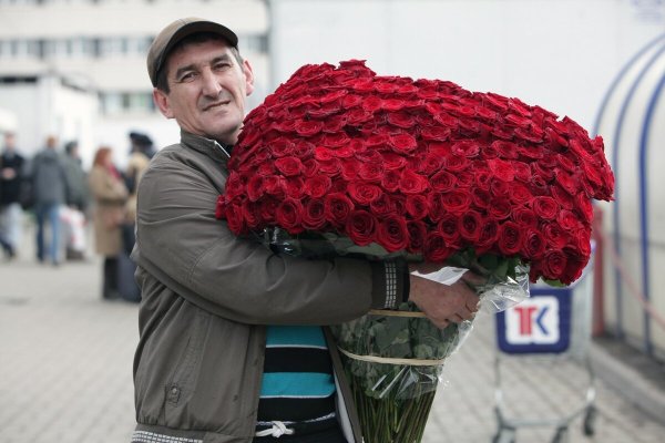 Человек держит огромный букет