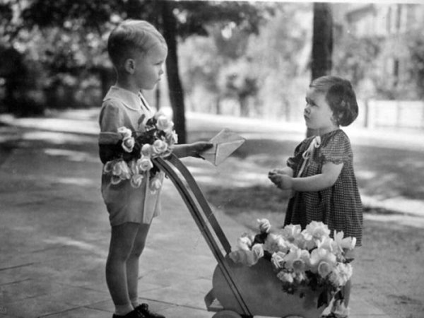 Мальчик дарит цветы девочке ретро