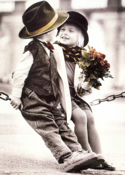 Маленький мальчик дарит цветы девочке