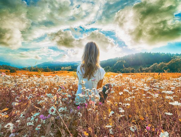 Девушка в поле со спины