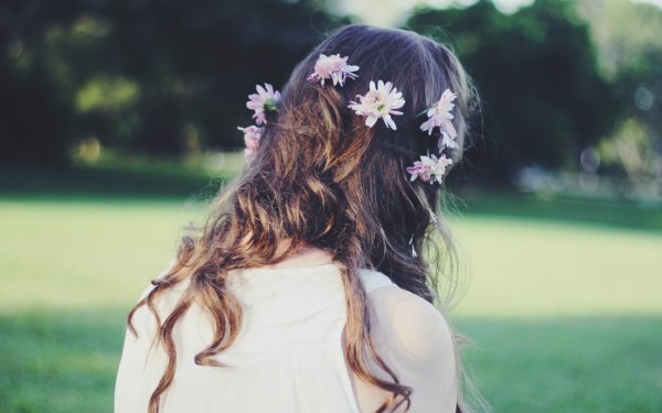 Девушка в поле цветов со спины