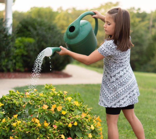 Девочка поливает цветы