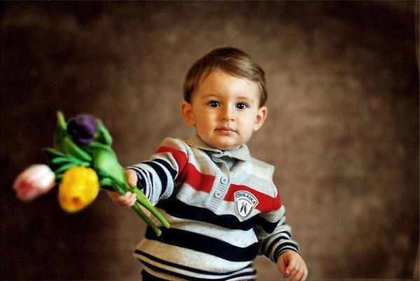 Мальчик дарит цветы маме