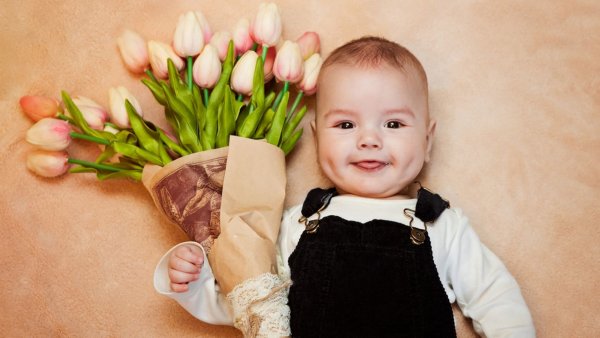 Мальчик дарит цветы маме