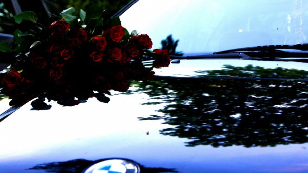 Букет цветов на капоте черной машины