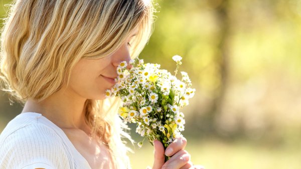 Девочка нюхает цветок