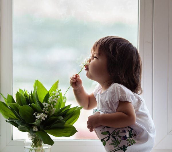 Девочка нюхает цветок