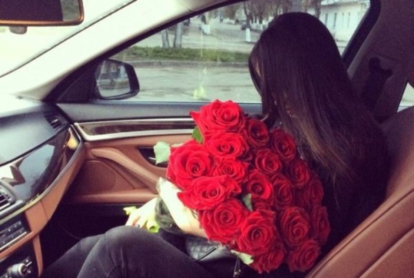 Брюнетка с цветами в машине