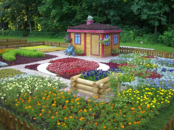 Девочка срывает цветы с клумбы