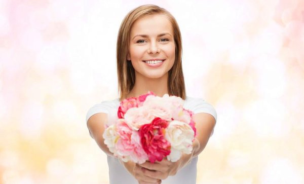 Девушка протягивает букет