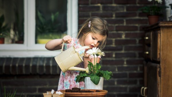 Ребенок поливает цветы