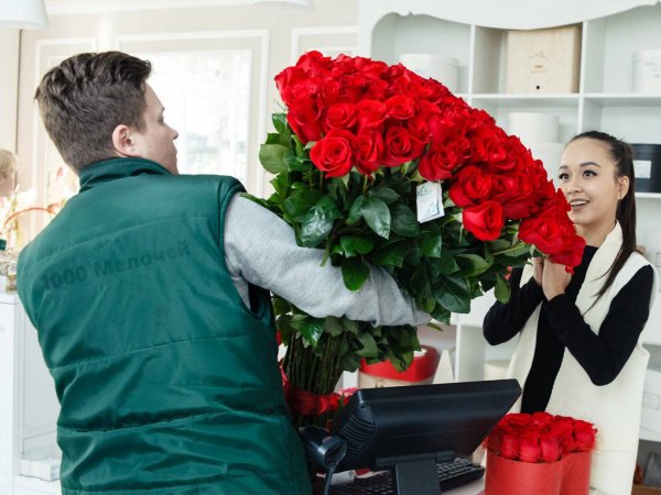 Парень дарит девушке цветы в машине