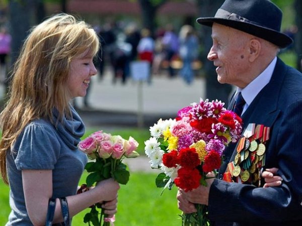 Мальчик дарит цветы ветерану