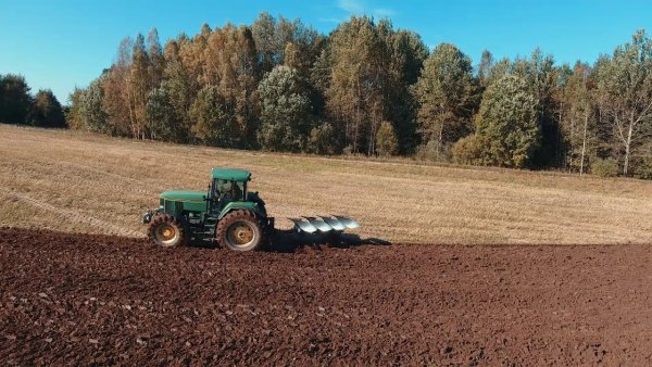 Трактор пашет поле