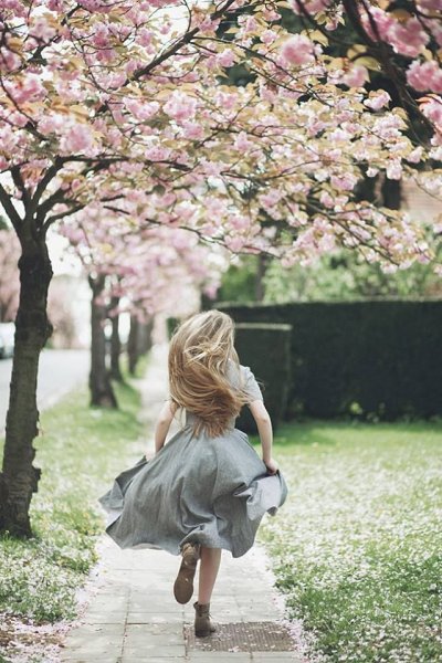 Блондинка в саду со спины