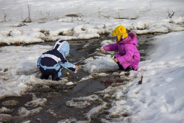 Ребенок пускает кораблики в ручье