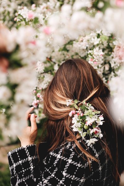 Девушка в цветущем саду со спины