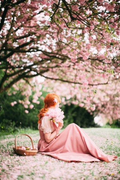 Рыжая девушка в цветущем саду