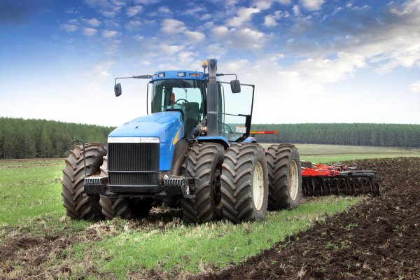 Трактор пашет землю