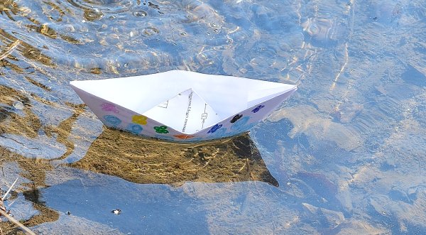 Бумажный кораблик в ручейке