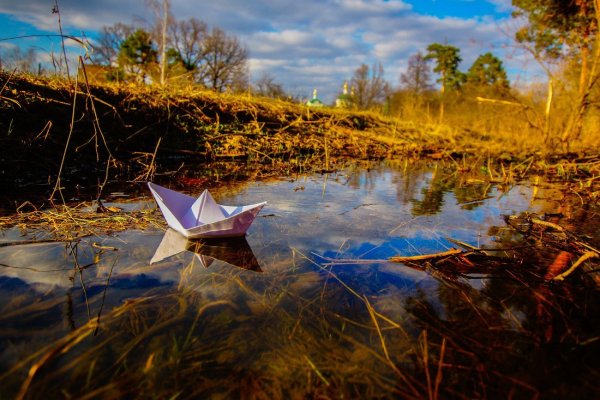 Бумажный кораблик в ручейке