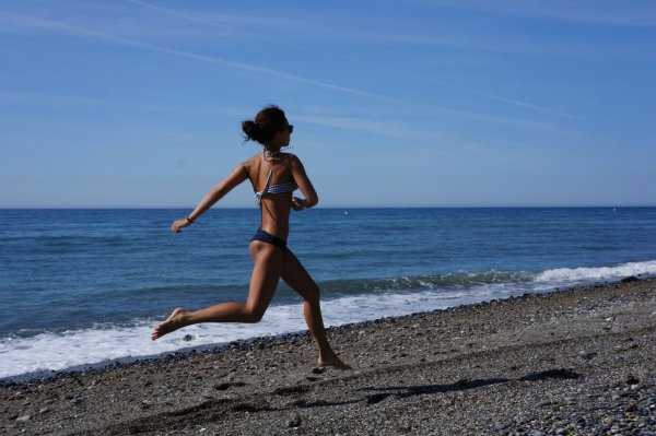 Девушка Бегущая по пляжу на закате