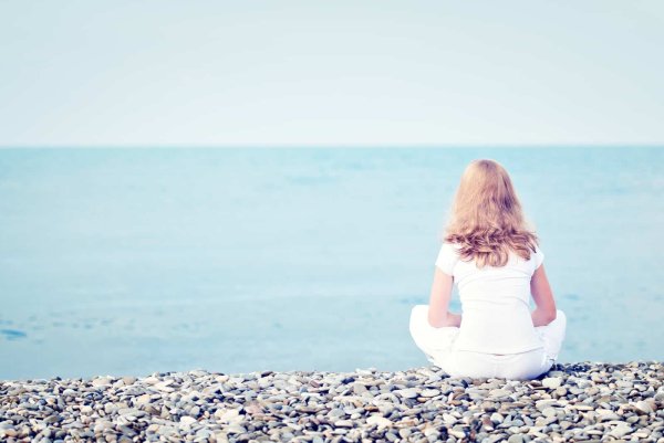 Девочка сидит на берегу моря