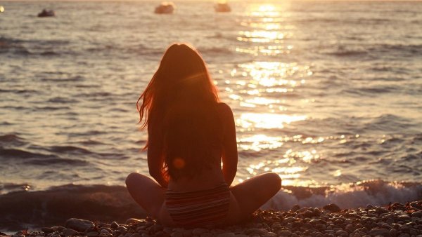 Девушка на берегу океана спиной