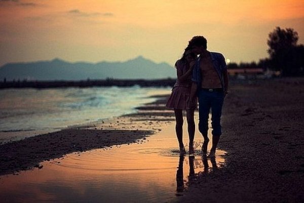 Парень с девушкой гуляют по берегу моря