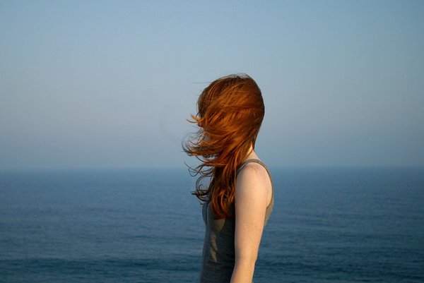 Рыжая девушка на море со спины