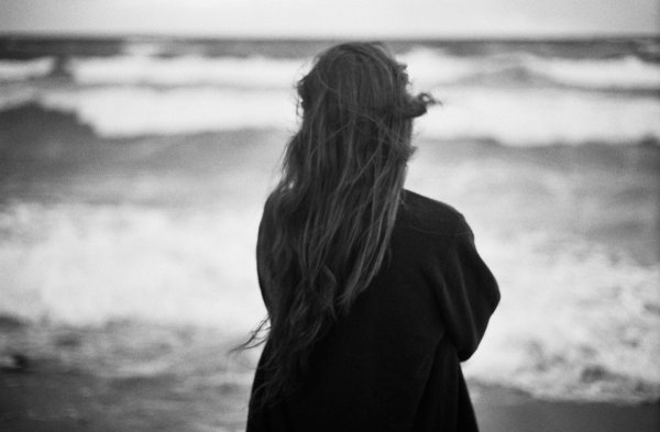 Рыжая девушка на море со спины