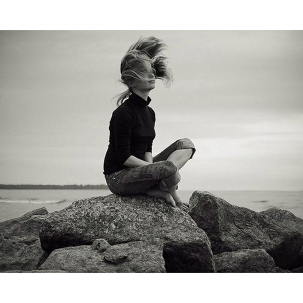 Девушка сидит на берегу