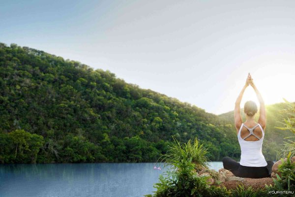 Девушка медитирует на берегу