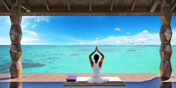 Девушка медитирует на берегу