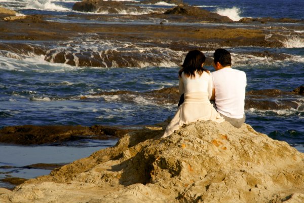 Двое влюбленных сидят на берегу