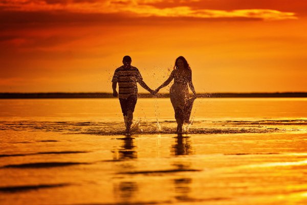 Пара на фоне заката у моря