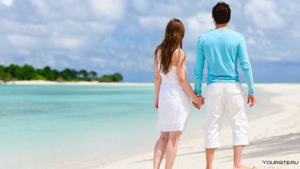 Мужчина и женщина идут по берегу моря