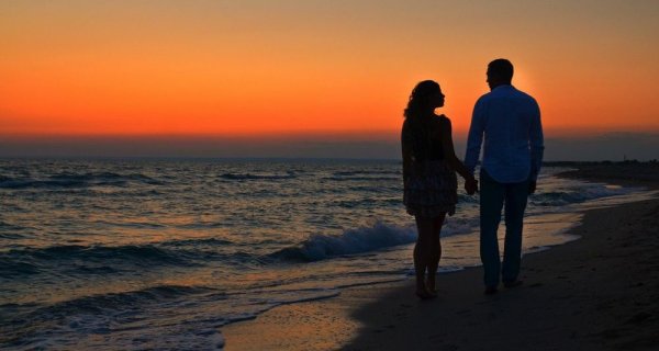 Пара идет по берегу