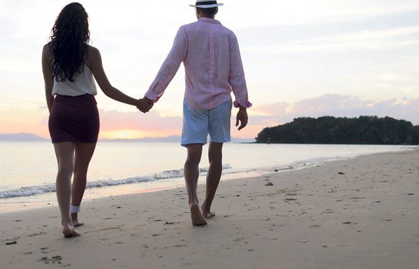 Парень и девушка гуляют по пляжу
