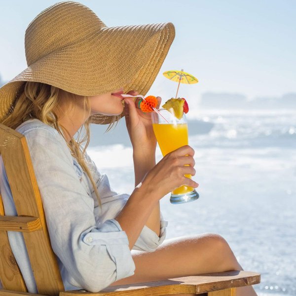 Блондинка на пляже с коктейлем
