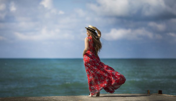 Девушка сидит на берегу моря