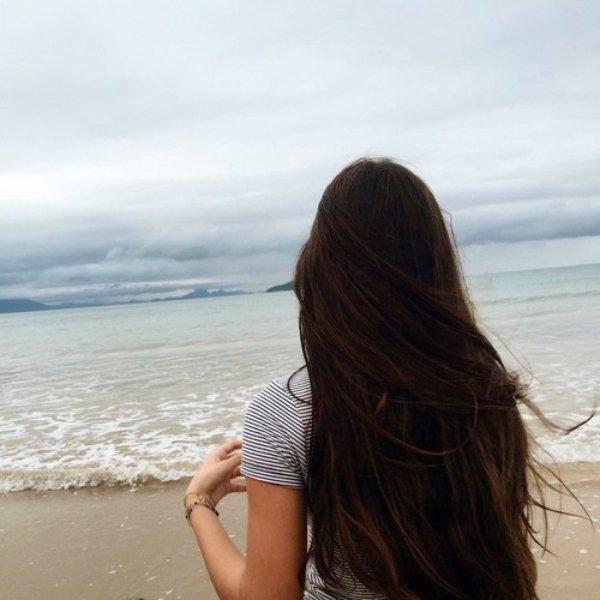 Брюнетка с длинными волосами на море