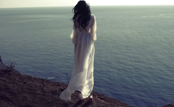 Брюнетка на море со спины