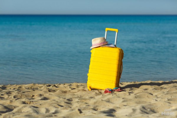 Желтый чемодан на пляже
